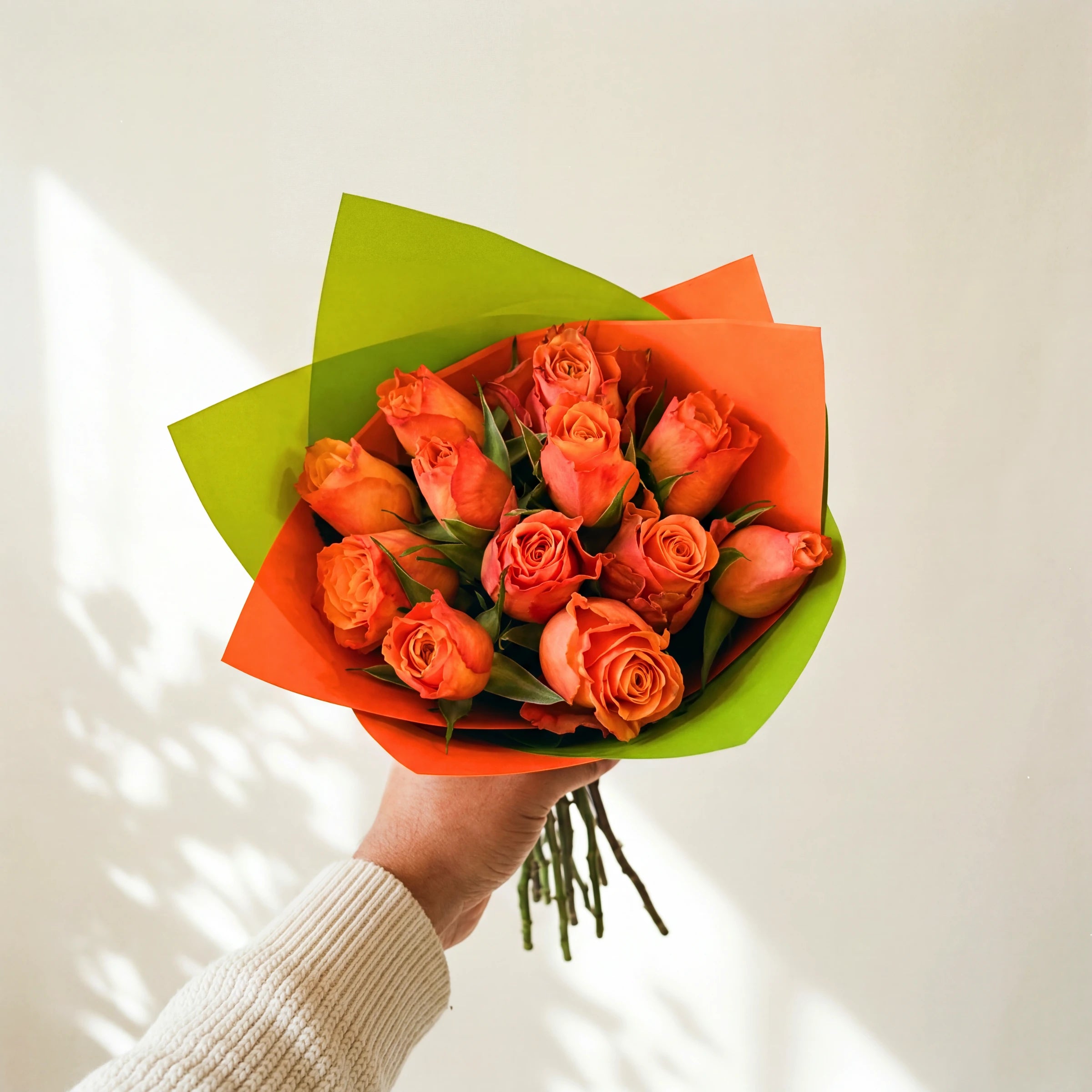 Marmalade, a dozen bright orange roses in a two-tone orange and lime green wrap, held by Fabulous Flowers