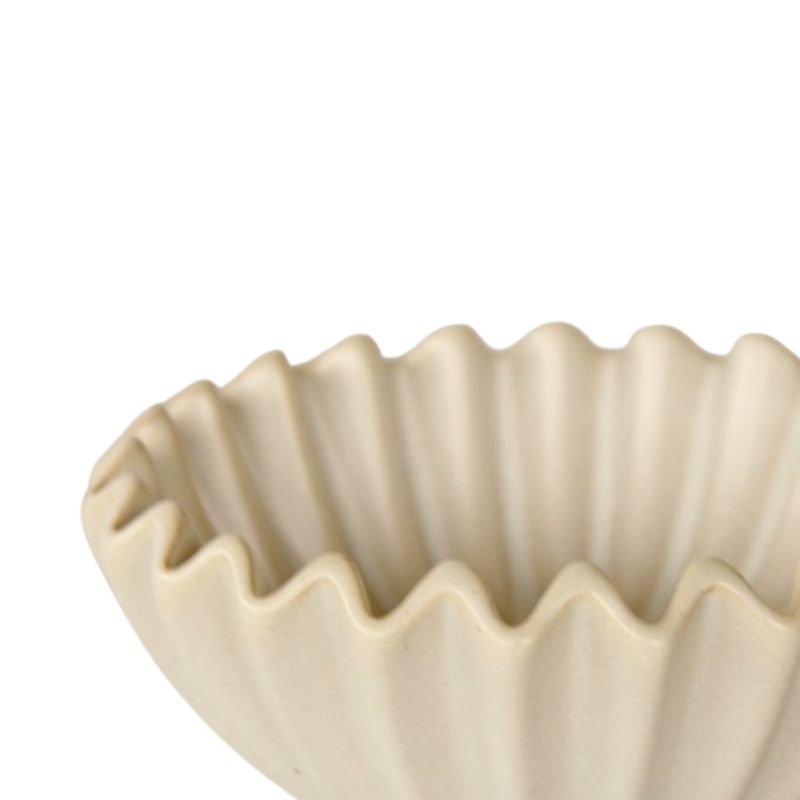 Beige ceramic bowl with wavy edge on a white background