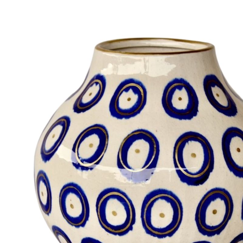 Ceramic vase with blue circular pattern on a white background
