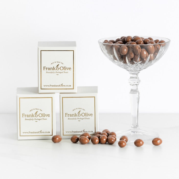 Mini Easter Box - Fabulous Flowers & Gifts white and gold box with chocolate-covered treats beside a glass dish for Easter gifting.
