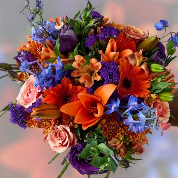 Bouquet of colorful flowers including orange, purple, and blue flowers.