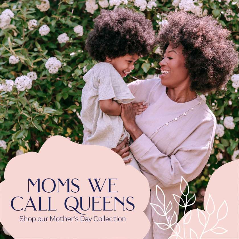 A heartwarming moment of a mother and child sharing a joyous embrace amidst blooming white flowers, epitomising the 'Moms We Call Queens' Mother's Day Collection at Fabulous Flowers and Gifts.