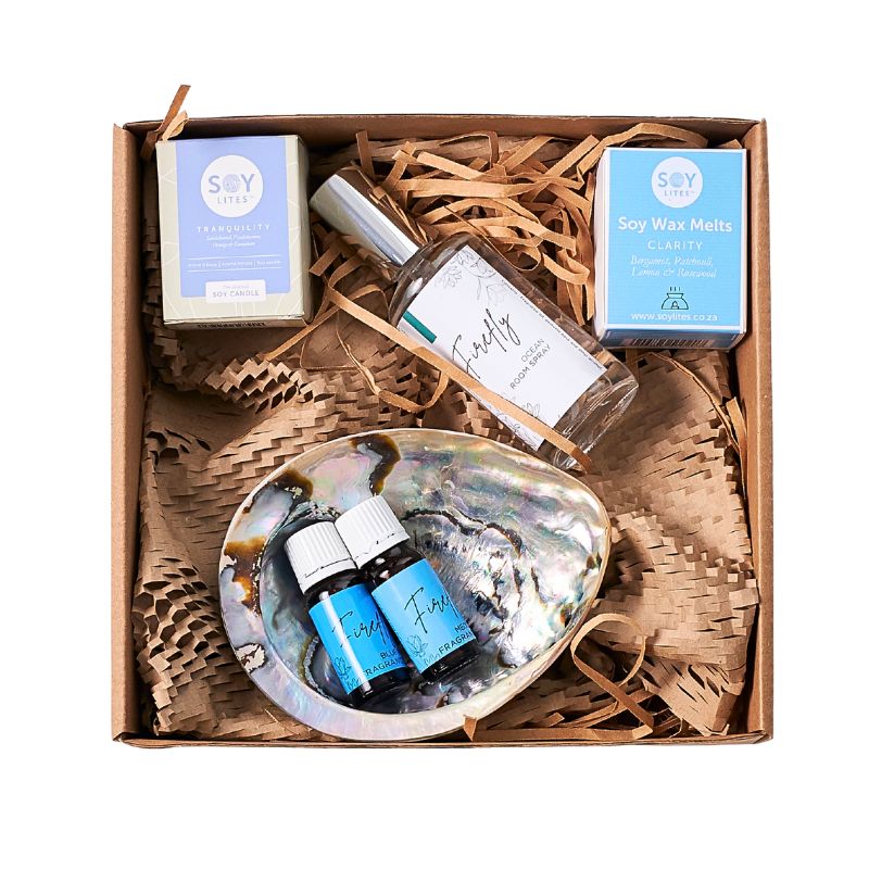 Gift set with soy wax melts, essential oils, and a shell on a white background