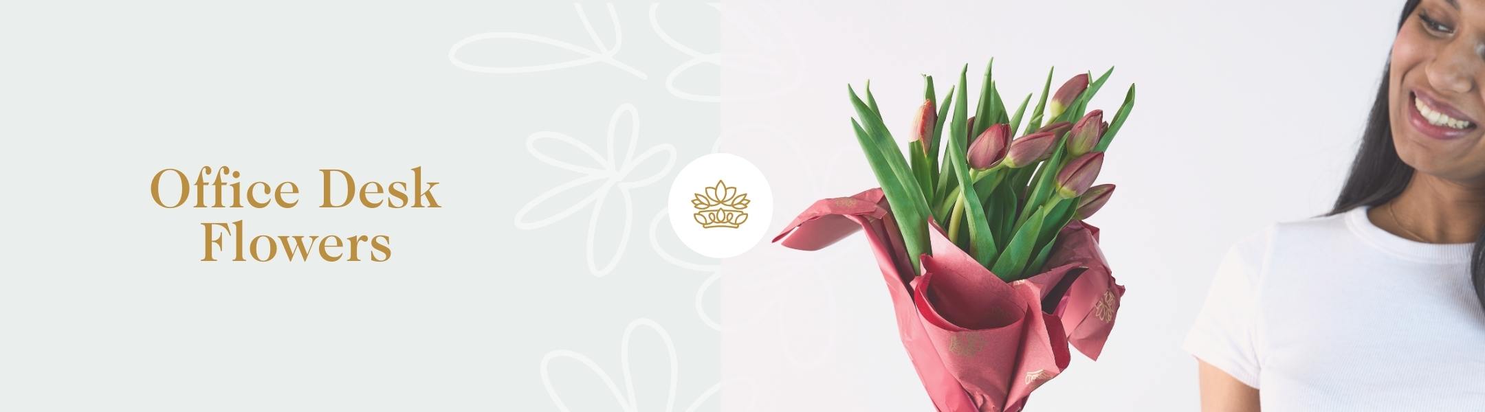 A joyful arrangement of red tulips in a vase, ideal for a productive workspace and uplifting office decor.