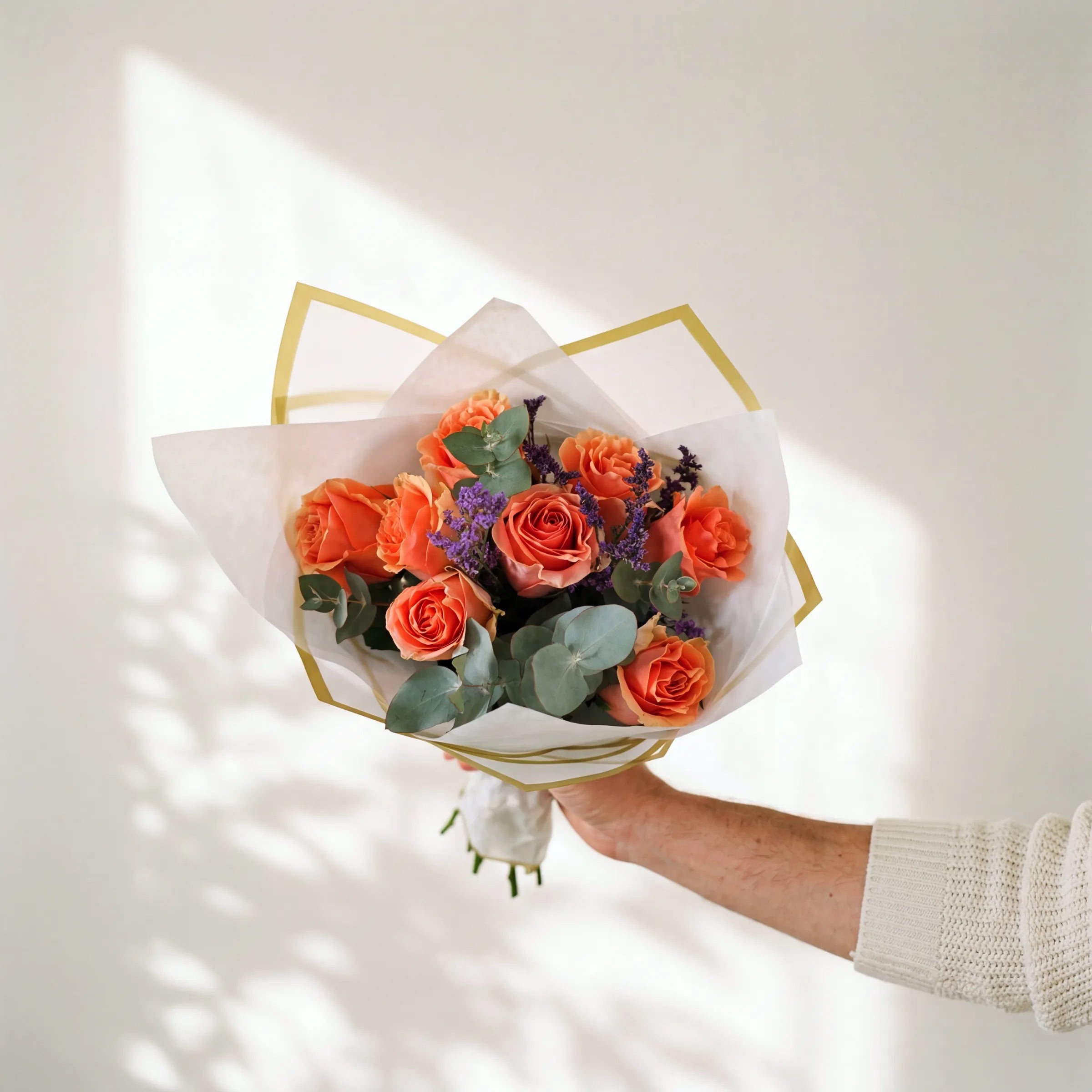 Small Orange Royale posy of coral-orange roses with eucalyptus and purple limonium in white and gold wrap, Fabulous Flowers