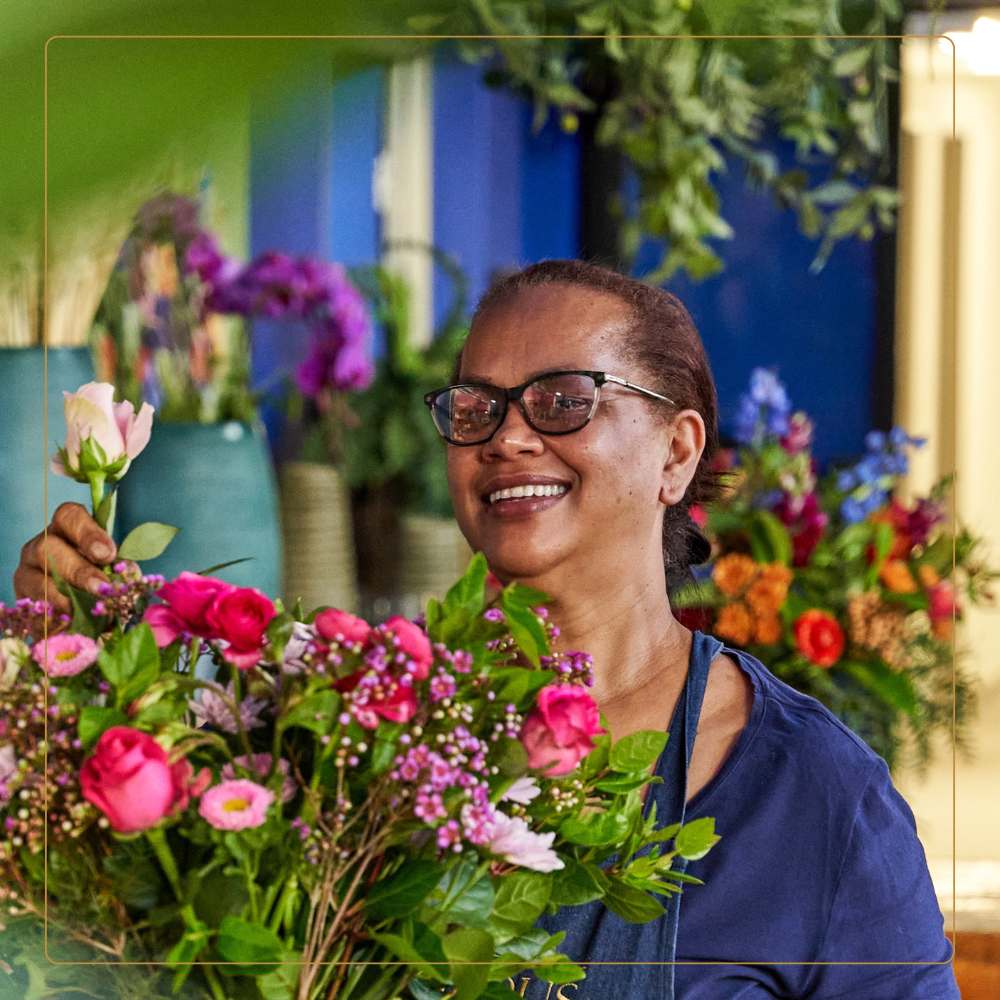 Seasoned florist preparing exquisite floral arrangement at Fabulous Flowers.