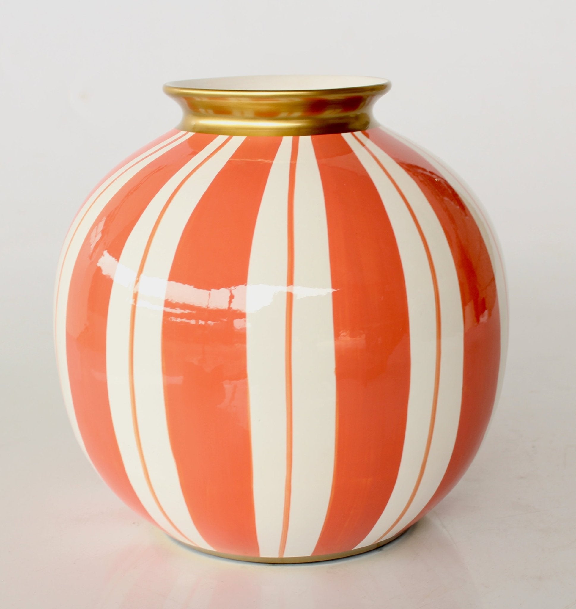 Decorative vase with orange and white stripes on a light gray background