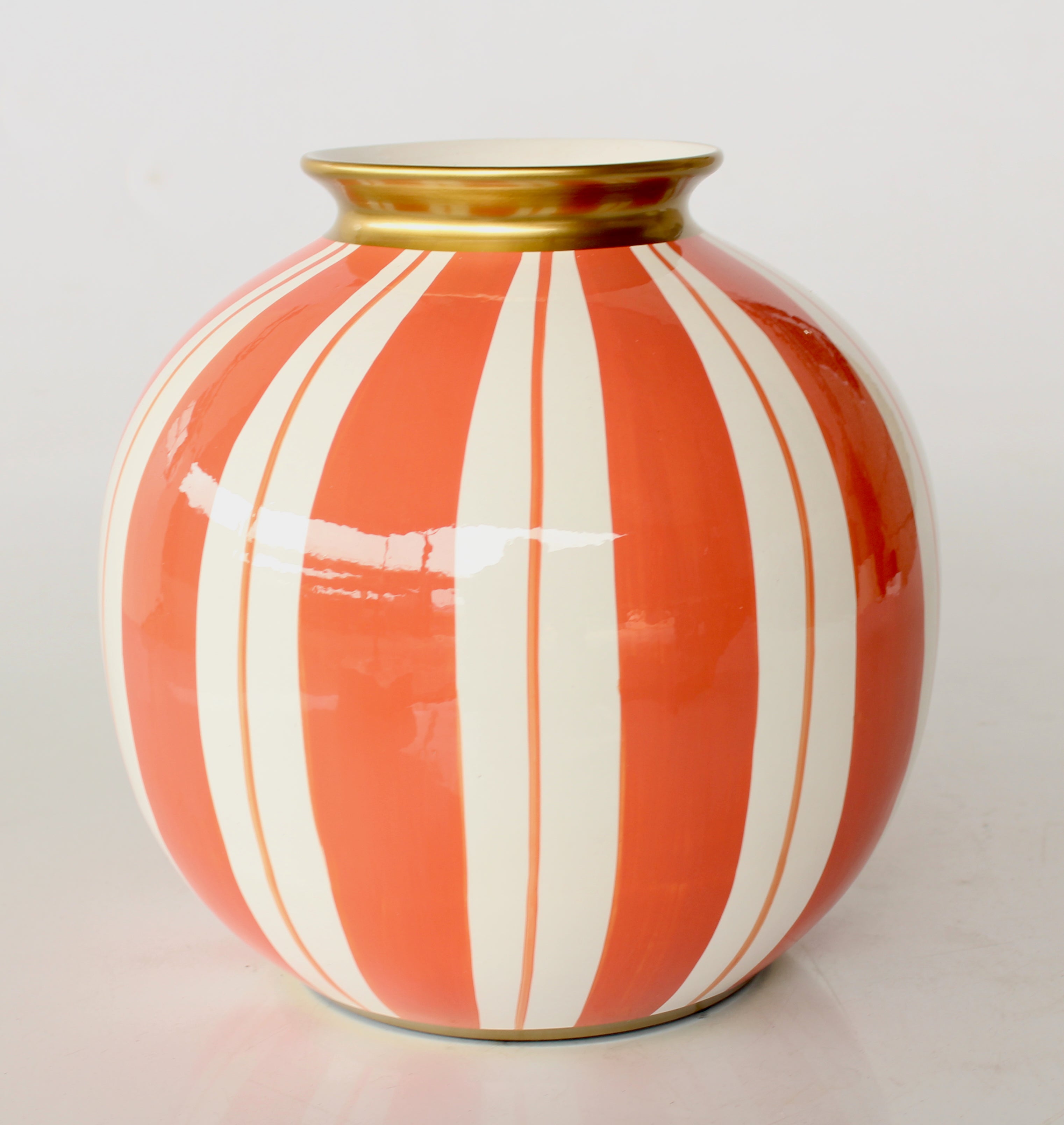 Decorative vase with orange and white stripes on a light gray background
