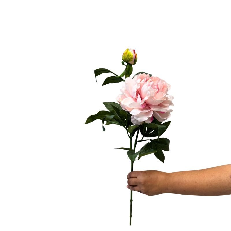 Hand holding a pink artificial flower stem against a white background