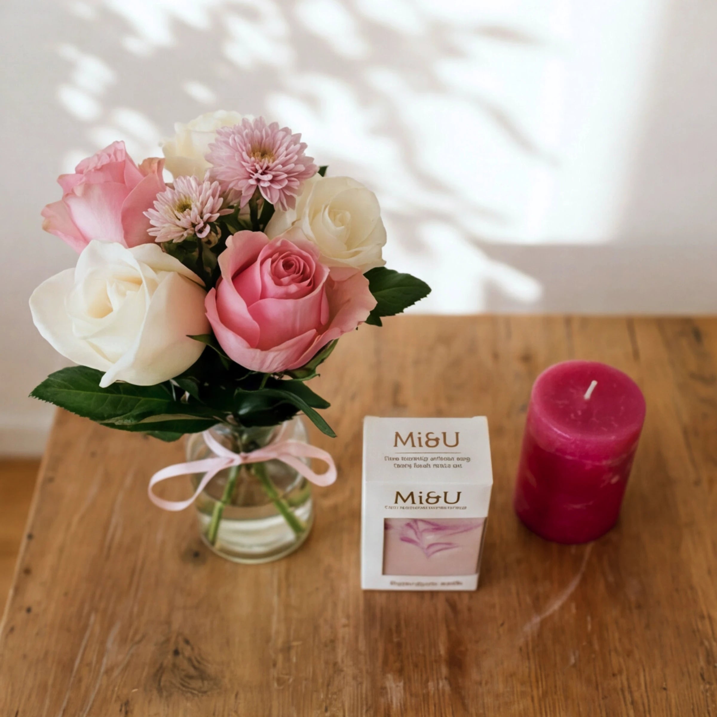 Petal & Flame gift set in soft light, pink roses in a vase, Mi&U soap and a hot pink candle