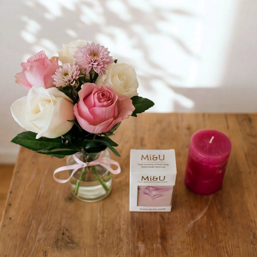 Petal & Flame gift set in soft light, pink roses in a vase, Mi&U soap and a hot pink candle