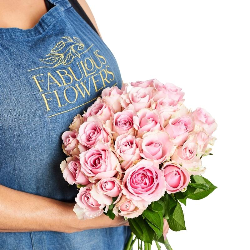 Florist holding a Pink Perfection bouquet of blush pink roses