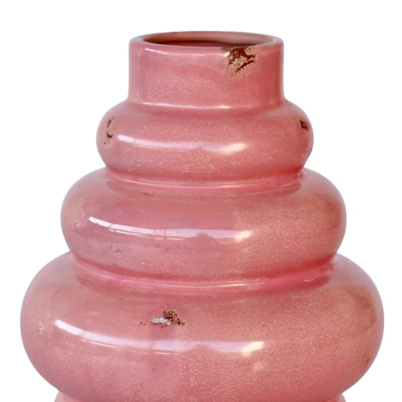 Pink ceramic vase with a textured surface on a white background