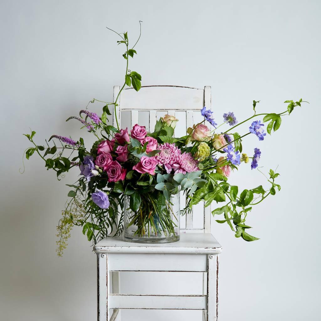 Modern flower arrangement in glass vase with pink roses, scabiosa, lisianthus, veronica and granadilla vines - Fabulous Flowers