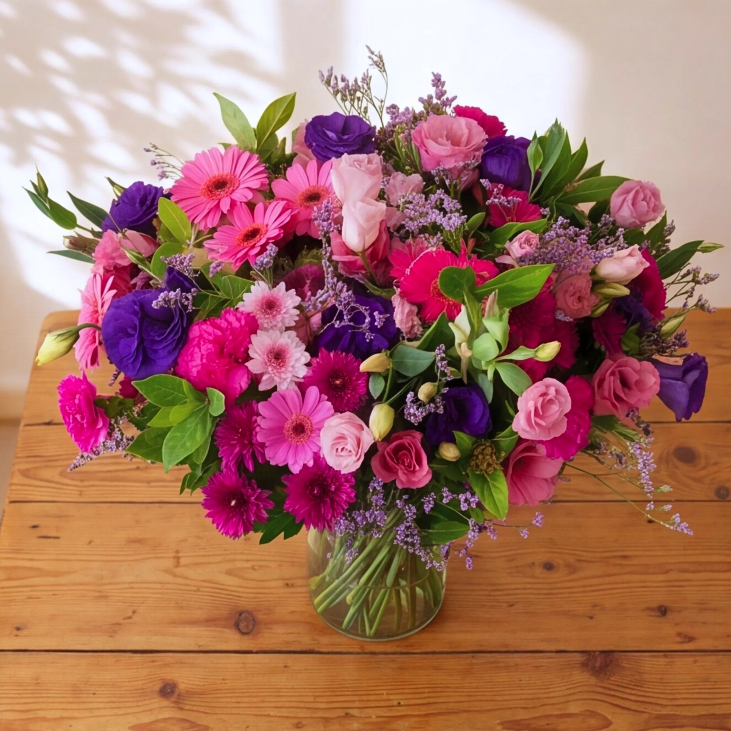Top view of Pretty in Pink and Purple vase arrangement with pink and purple lisianthus, gerbera, carnations and statice
