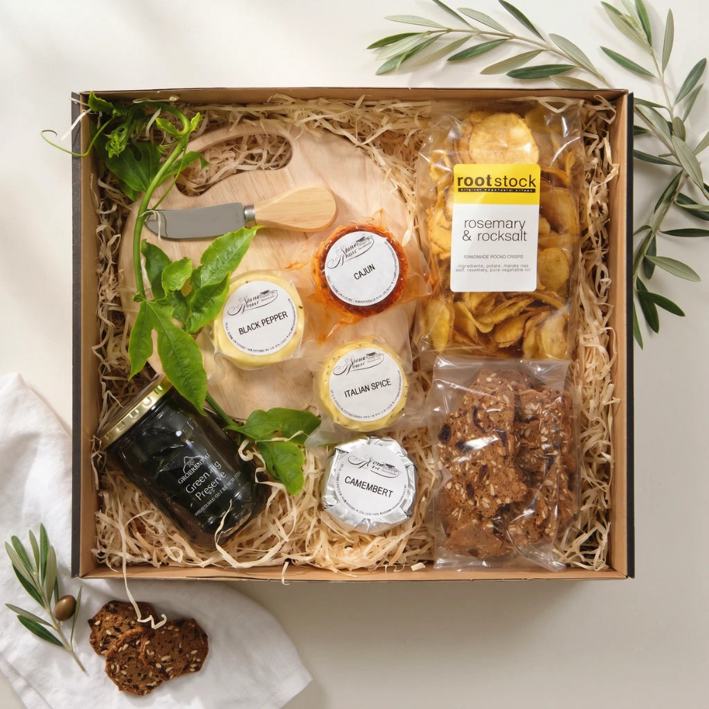 Ready to Share Picnic Basket flat-lay in kraft box with cheese wheels, crackers, Rootstock chips, fig preserve and wooden board, Fabulous Flowers