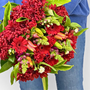Red flower bouquet including gerberas, lilies, snapdragons, roses held by local florist - Fabulous Flowers