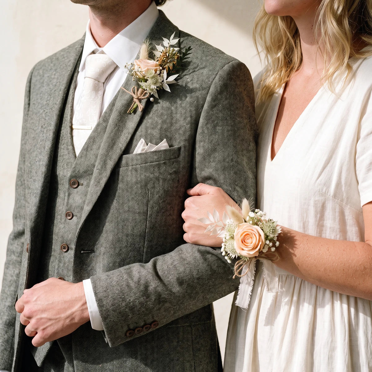 Couple in tweed and a cream linen dress wearing a matching rustic boutonniere and corsage, Fabulous Flowers South Africa