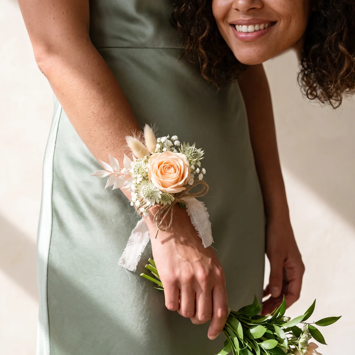 Bridesmaid in a sage green dress wearing a rustic peach rose wrist corsage, Fabulous Flowers South Africa