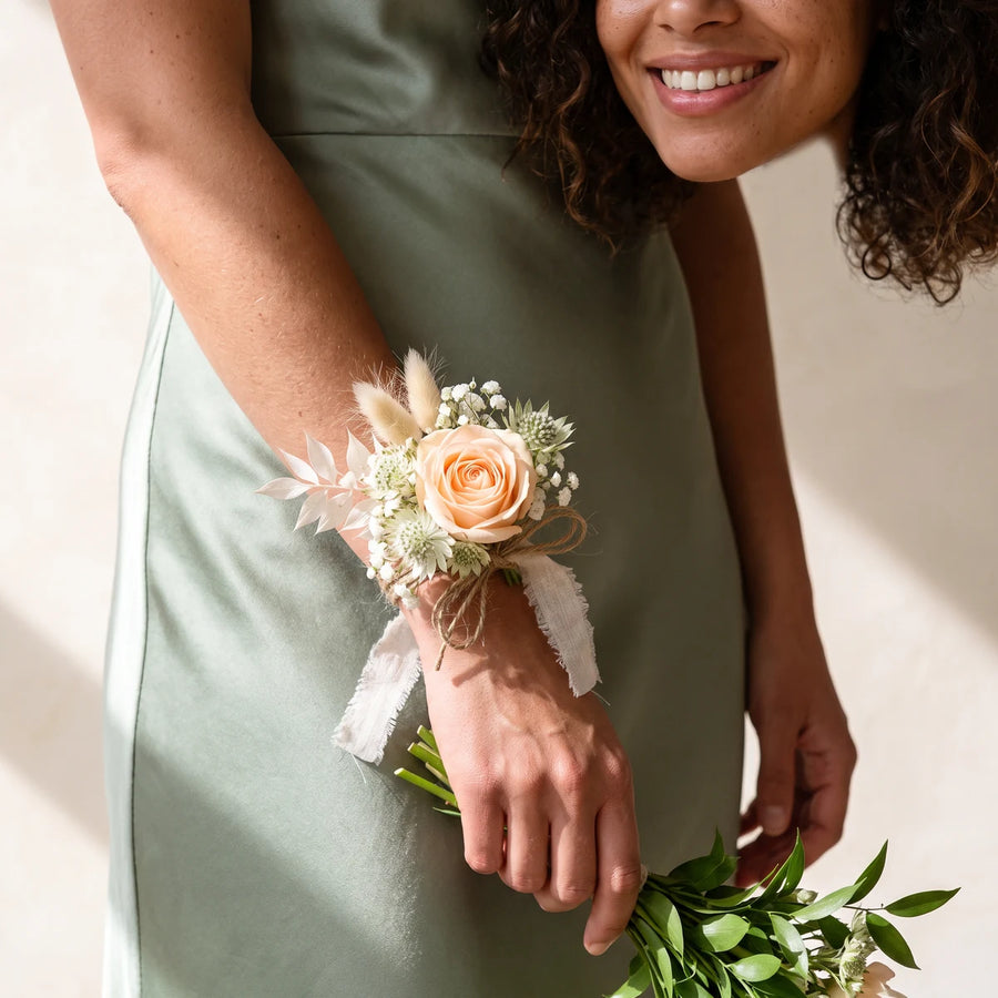 Bridesmaid in a sage green dress wearing a rustic peach rose wrist corsage, Fabulous Flowers South Africa