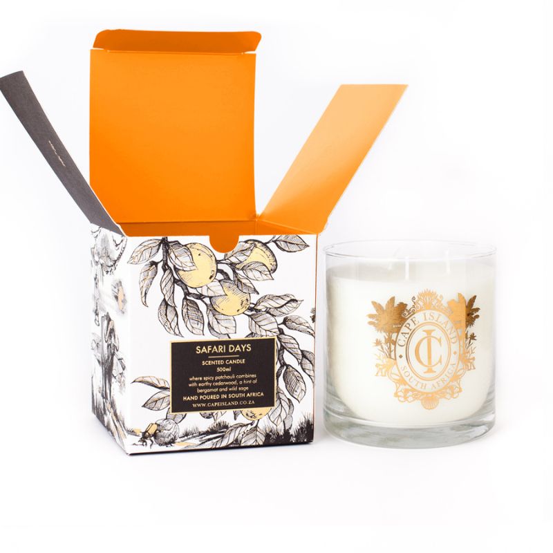 Cape Island “Safari Days” scented candle next to its open gift box with orange interior and botanical print.