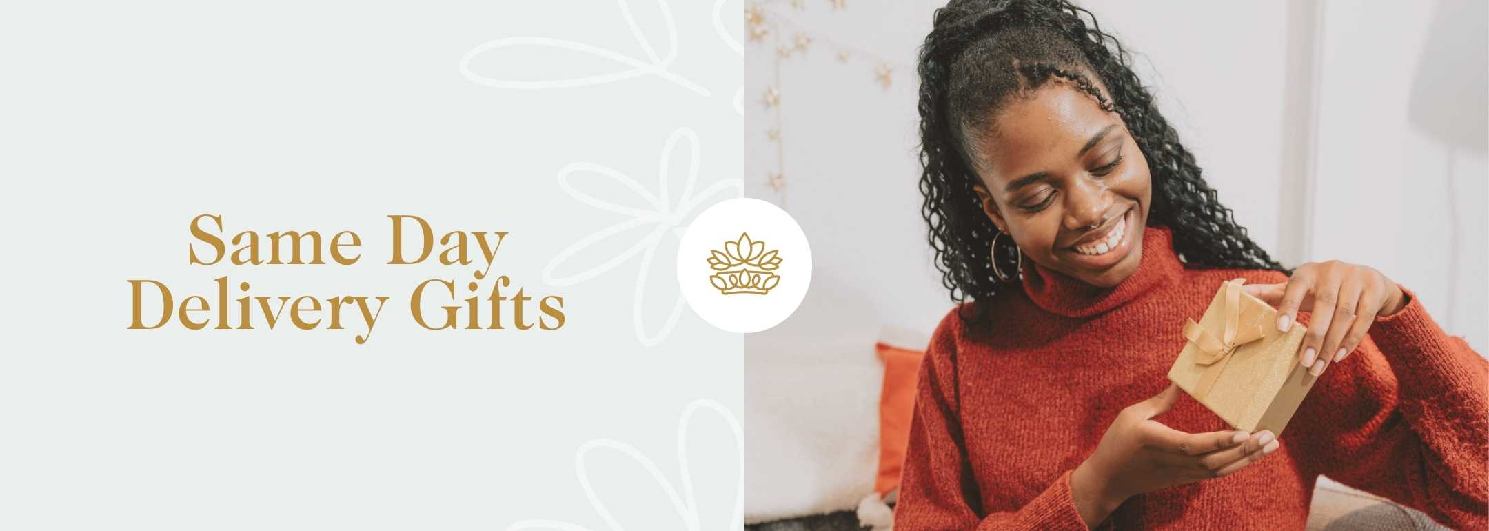 Wide banner image featuring a joyful woman in a red sweater, smiling as she unwraps a small gift wrapped in golden paper. The background is softly decorated with light grey tones and subtle floral designs. On the left, elegant gold text reads 'Same Day Delivery Gifts' beside a delicate white floral logo, highlighting the convenience and delight of quick gift-giving services.