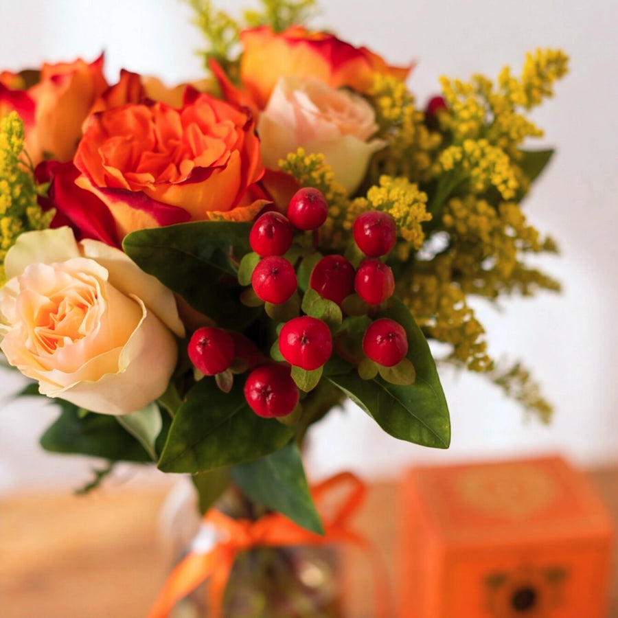 Close up of sunset roses, cream garden roses and red hypericum berries in the Savanna & Sun posy