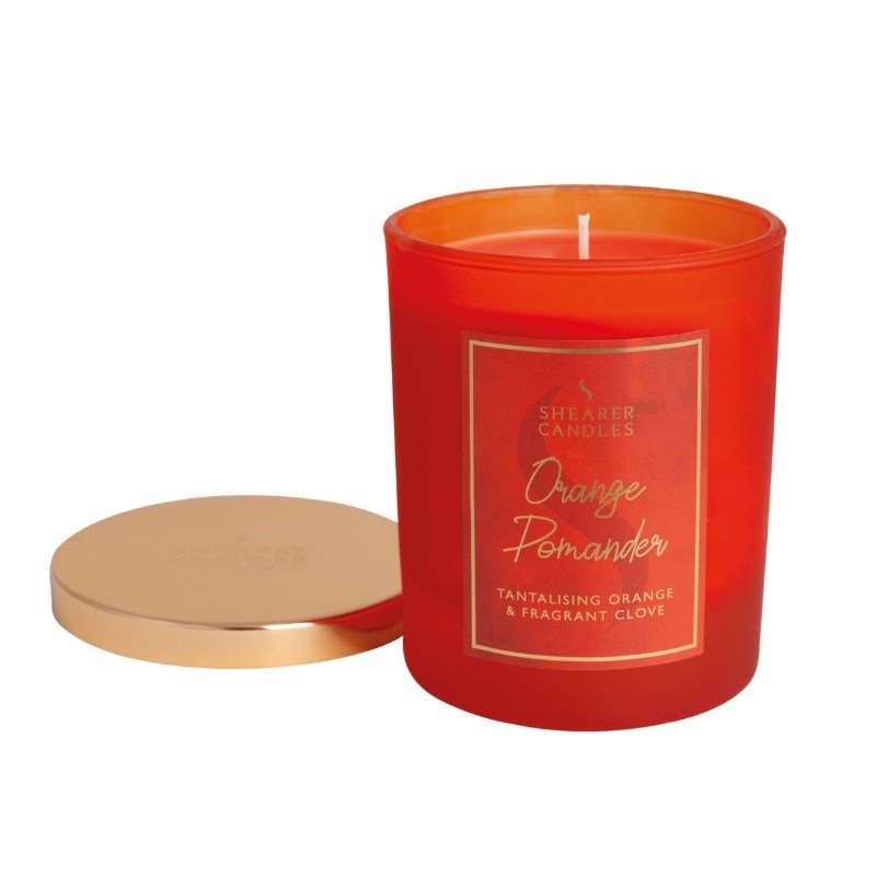 Orange candle with a gold lid on a white background