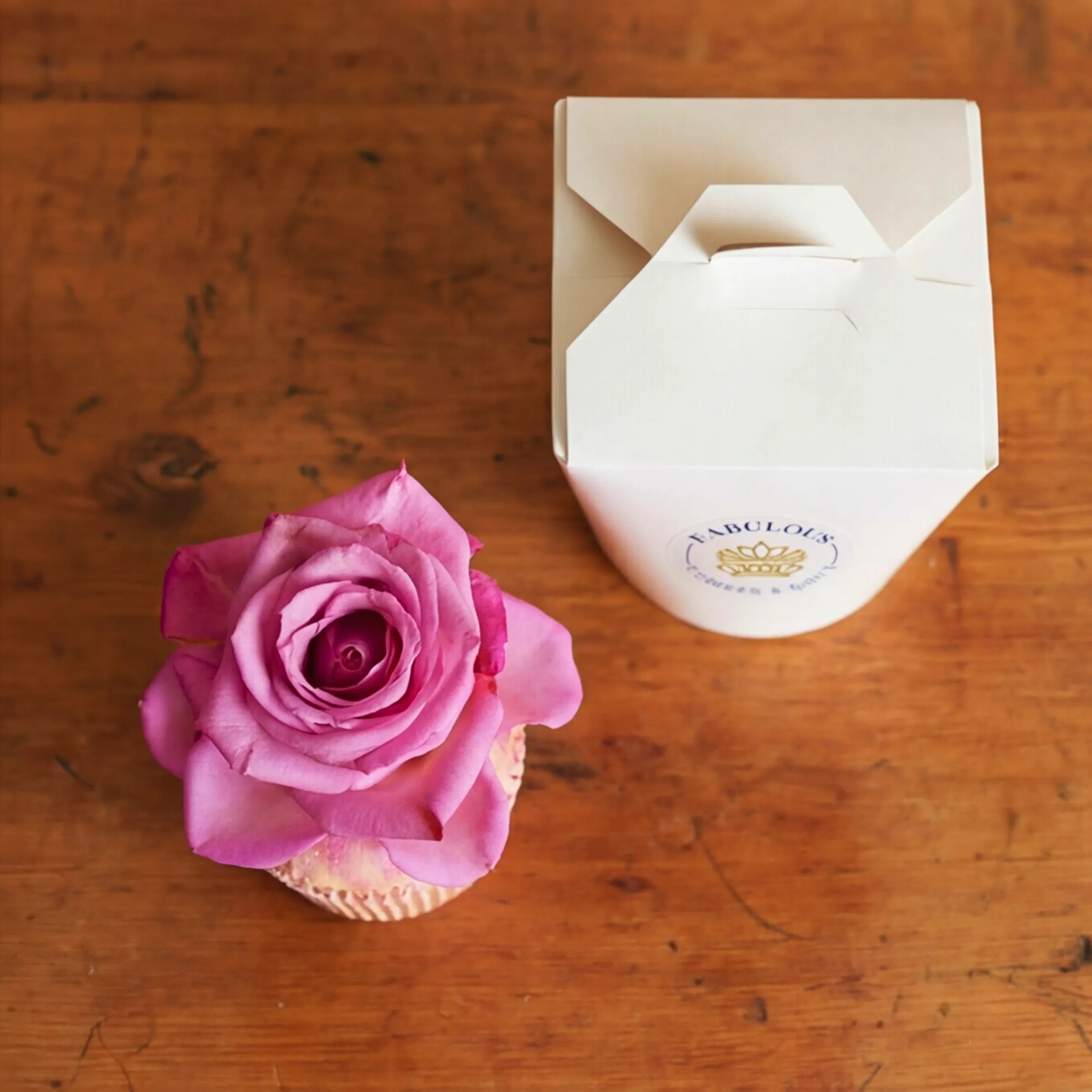 Top view of Single Vanilla Cupcake with real pink rose, edible glitter and Fabulous Flowers gift box