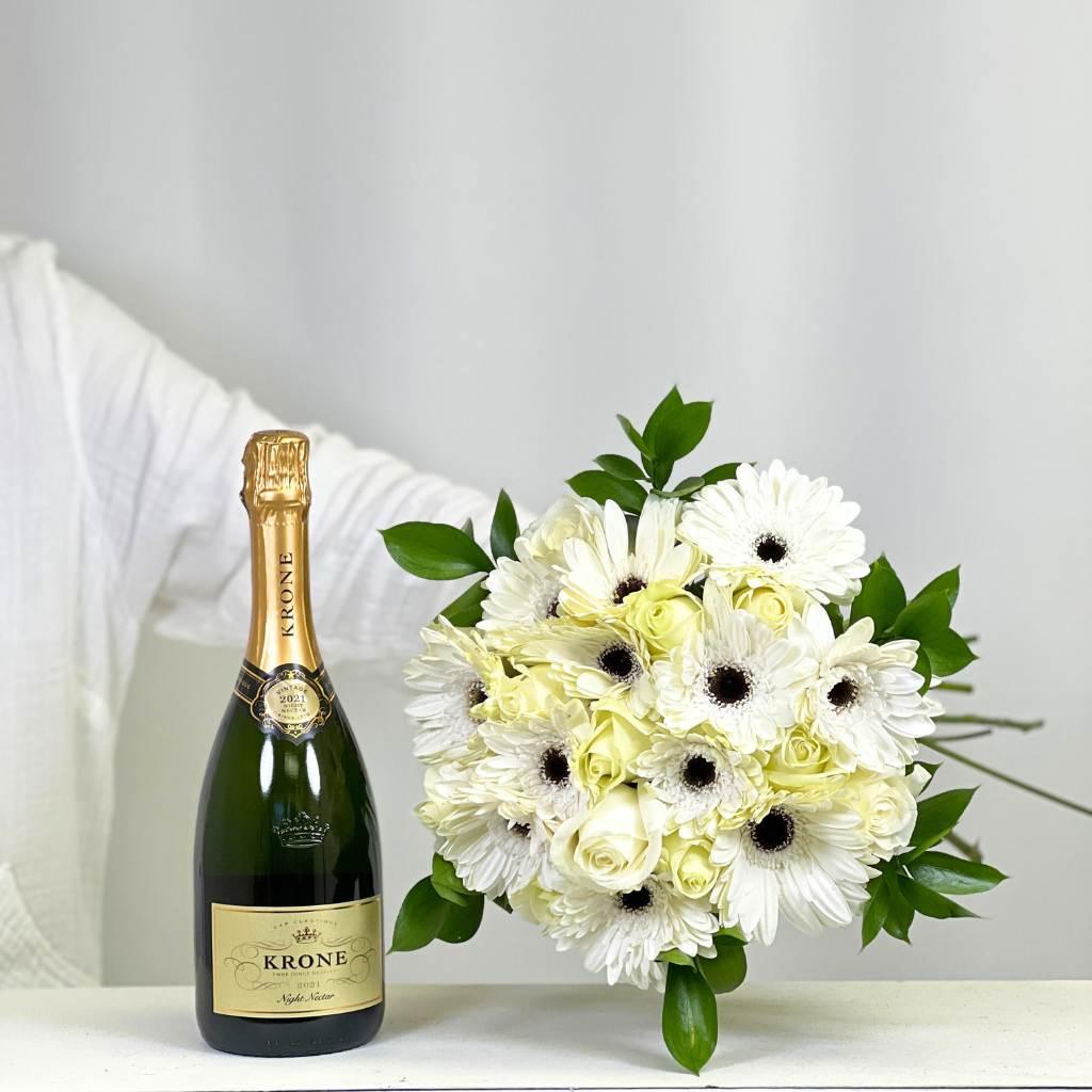 Florist holding White flower bouquet with roses and gerberas paired with Krone Night Nectar - Fabulous Flowers