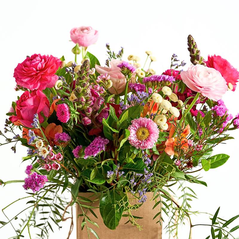 Close up of posy box of colorful flowers in a cardboard box on a white background