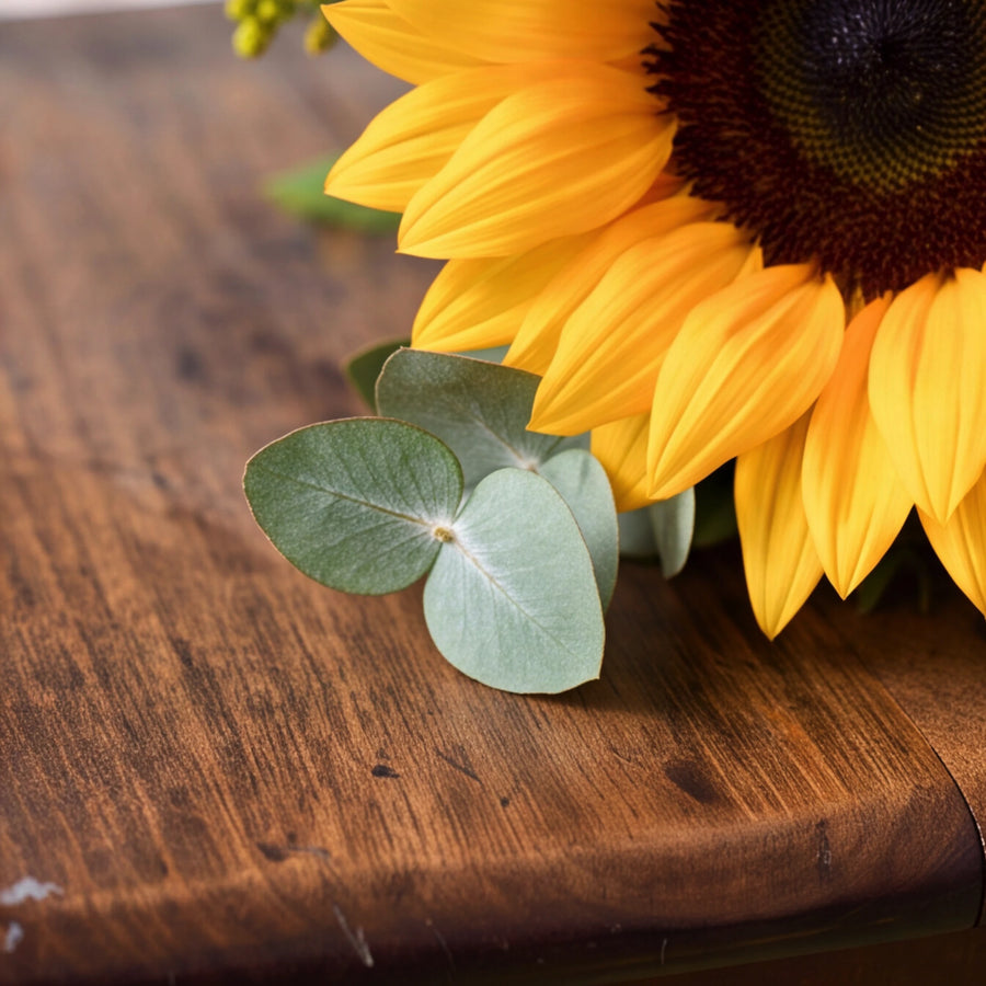 Close-up of a golden sunflower with silver eucalyptus leaves in the Fabulous Flowers Sunflower Posy