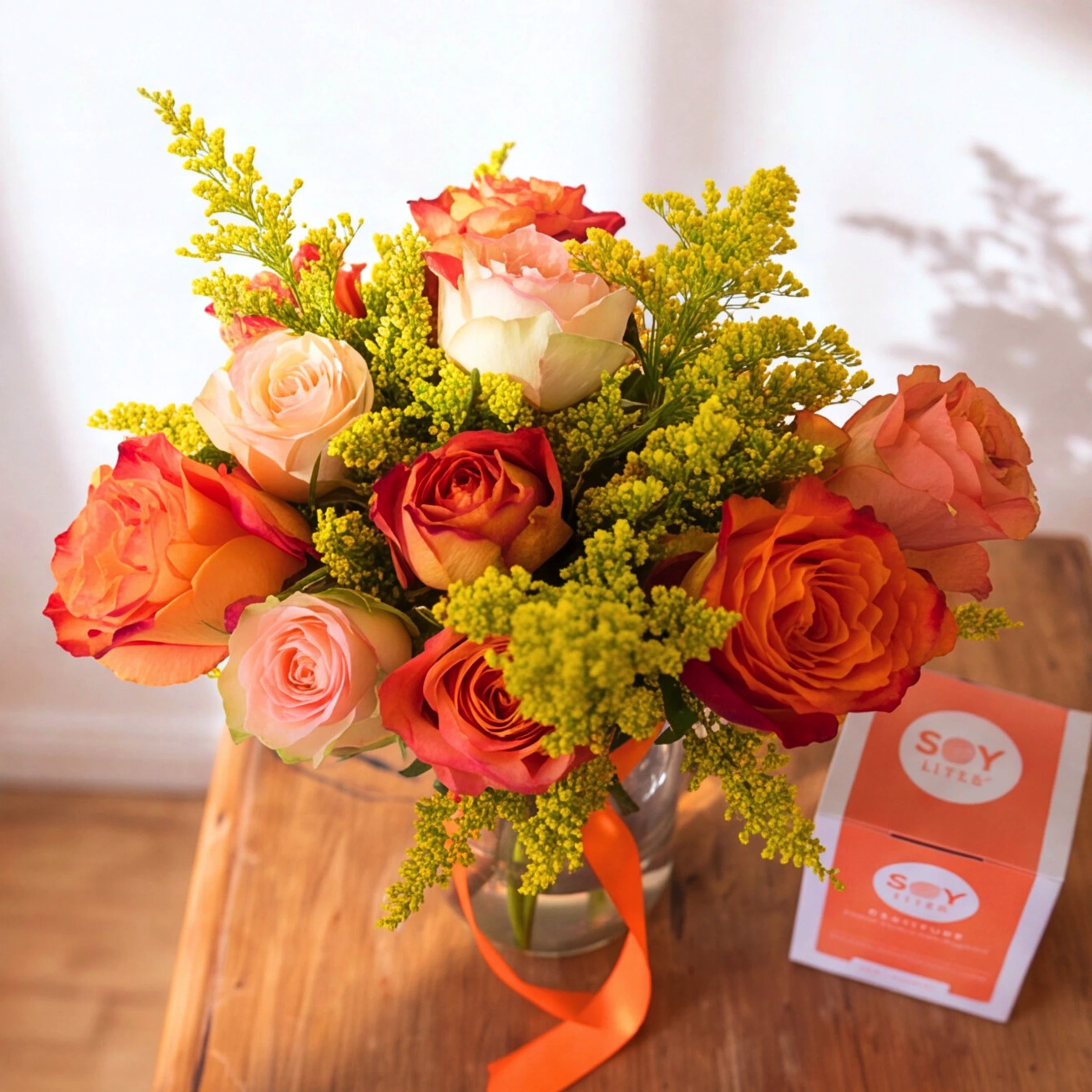 Sunlit Gratitude orange rose and soy candle gift set in a clear glass vase with orange ribbon