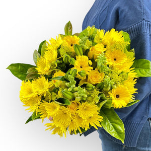 Florist holding the Sunny Delight Bouquet wrapped elegantly in eco-friendly packaging - Fabulous Flowers