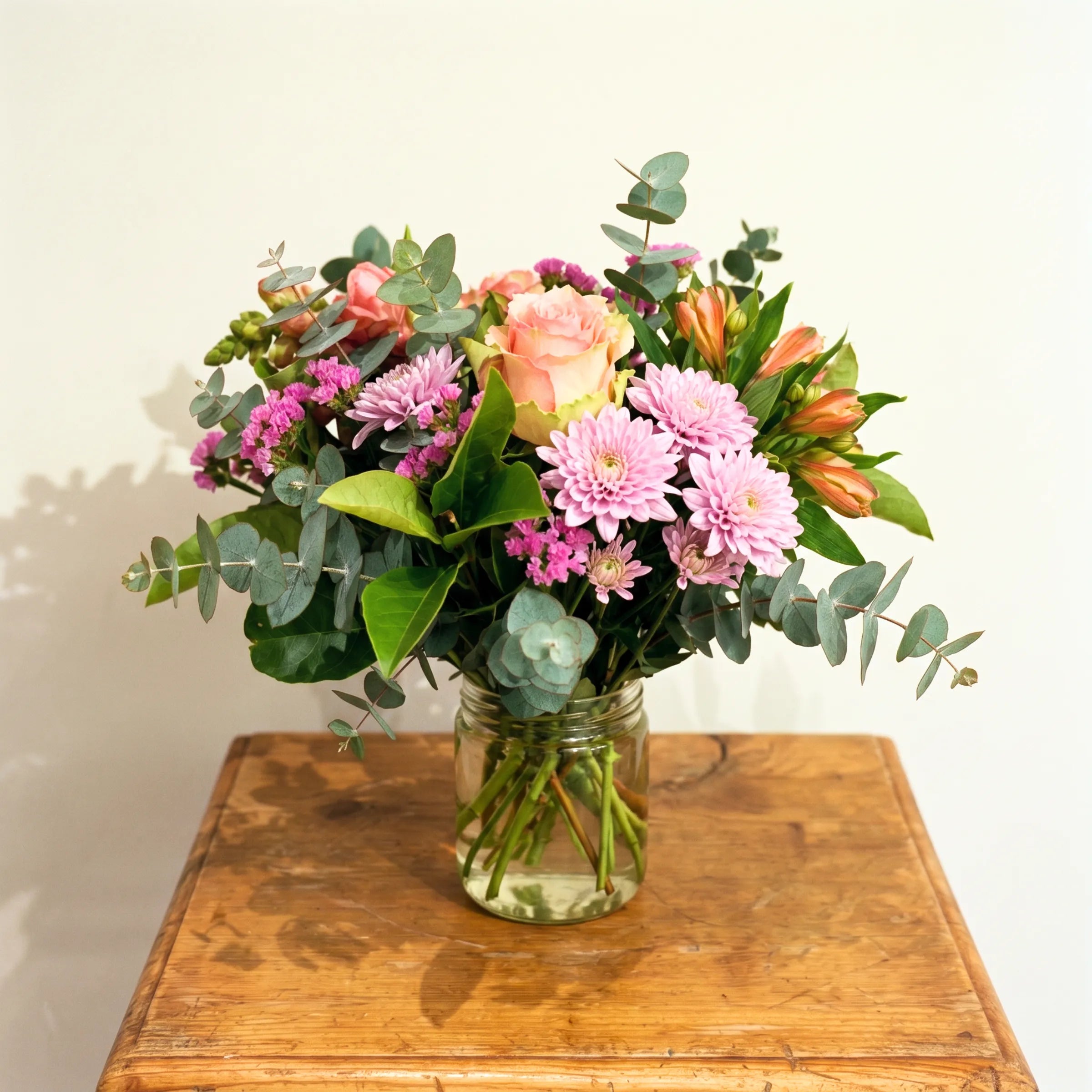 Sweet Pea in a Jar peach roses, pink chrysanthemums, statice and eucalyptus posy in a glass jar by Fabulous Flowers
