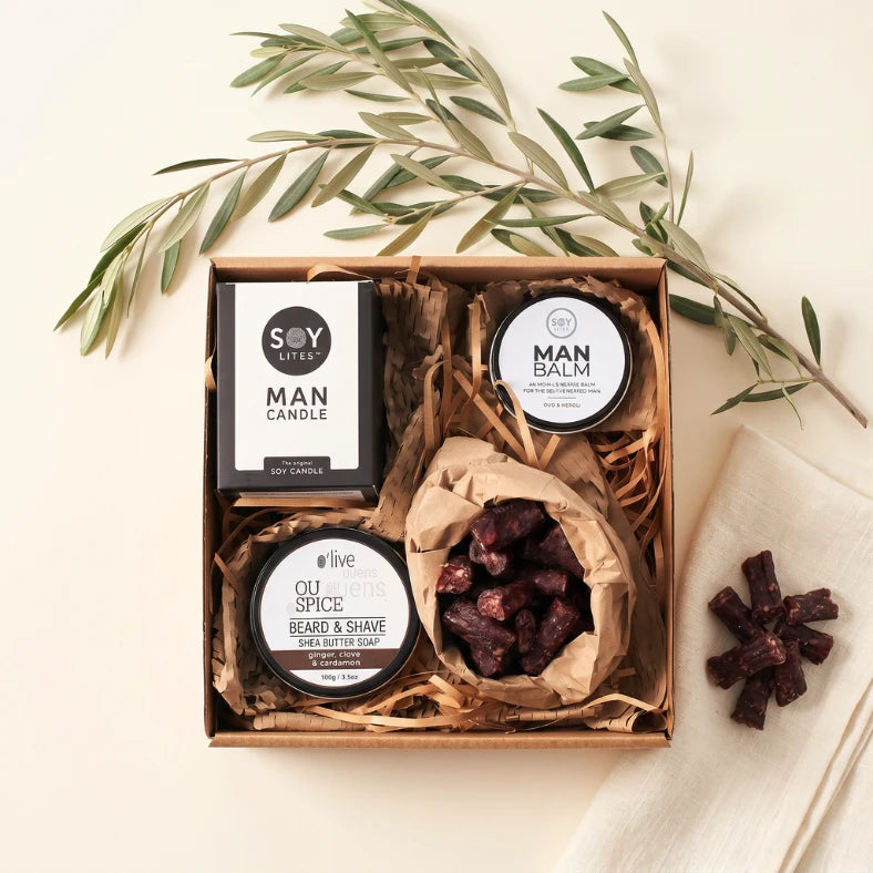 Essentials gift box for men styled with Soy Lites Man Candle, open Man Balm tin, OU Spice beard and shave soap and droëwors, Fabulous Flowers and Gifts