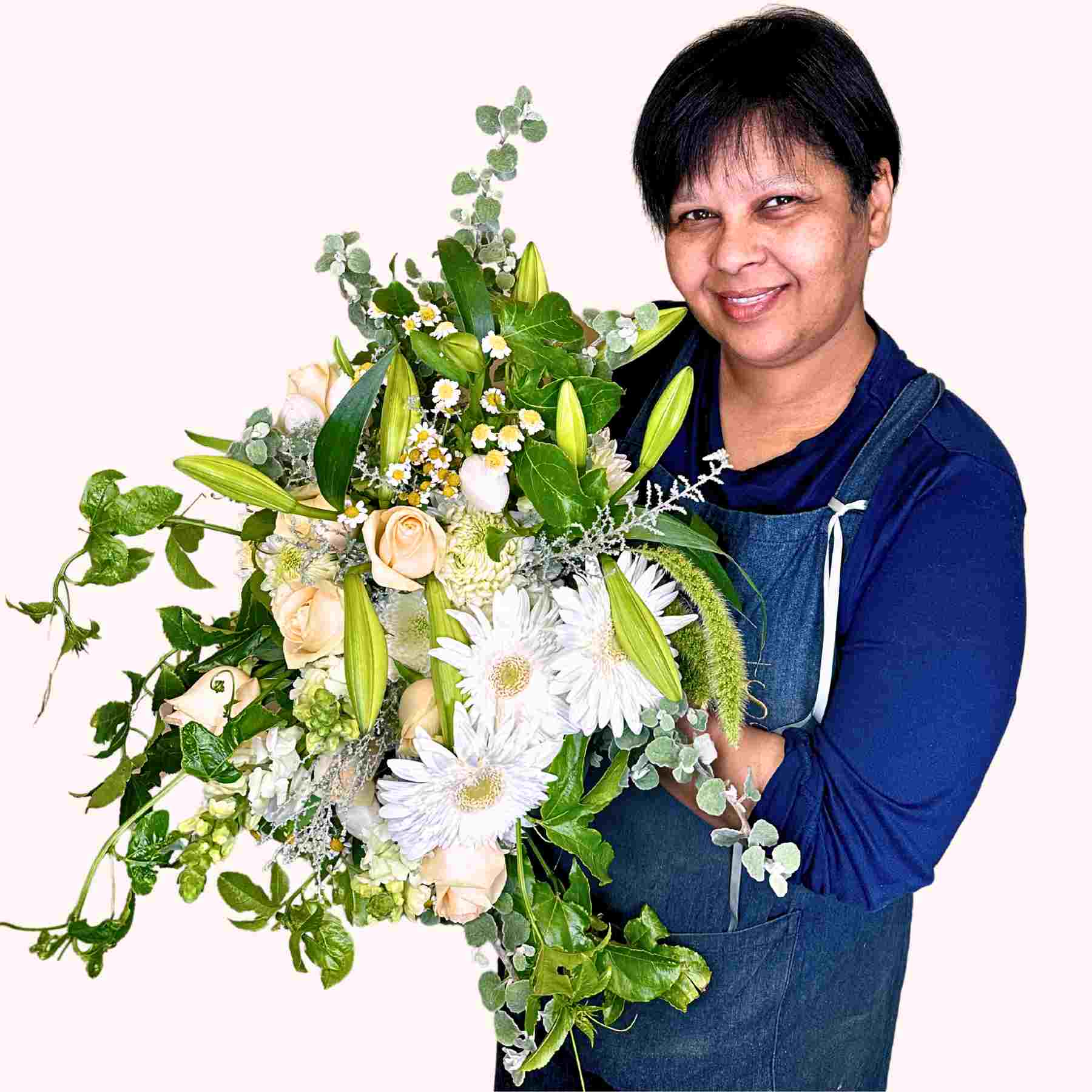 Smiling florist, Tracey, holding a diverse bouquet of roses, gerberas, and lilies named Tracey's Flower Bouquet from Fabulous Flowers and Gifts.
