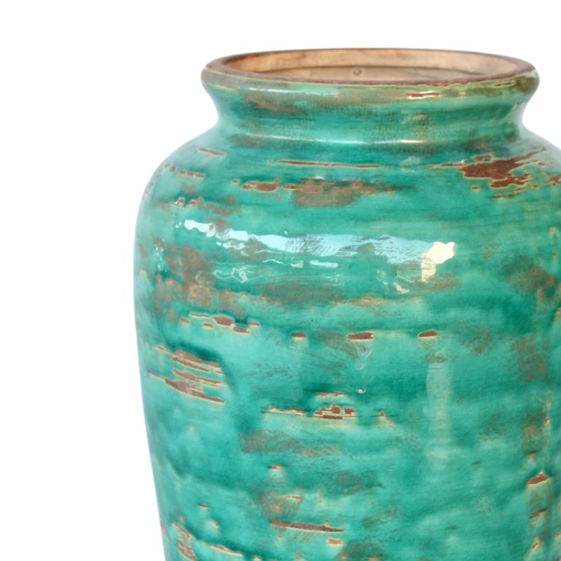 Turquoise ceramic vase with a textured surface on a white background