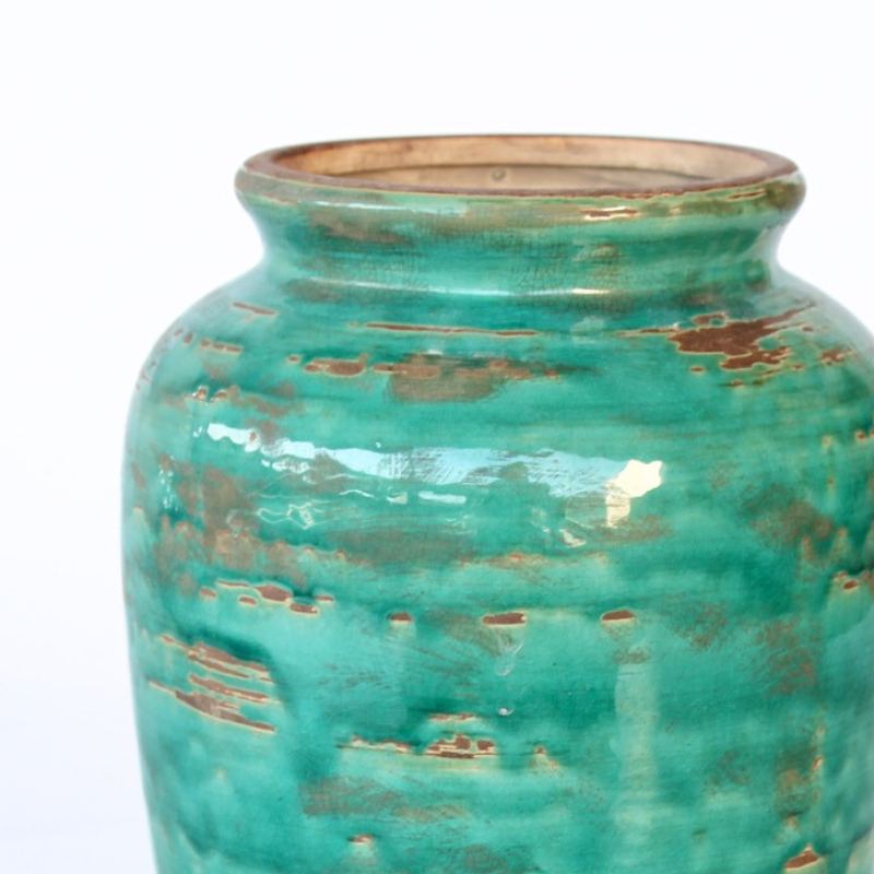 Turquoise ceramic vase with a textured surface on a white background