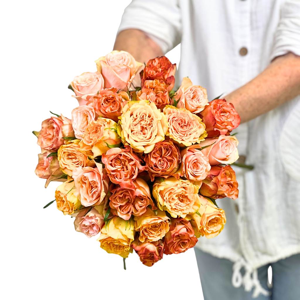 Bouquet of multicolored roses held by a person wearing a white shirt.