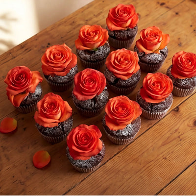 A dozen chocolate cupcakes arranged on a rustic wooden table, each topped with a vibrant orange rose and finished with icing-sugar dusting, Fabulous Flowers Cape Town corporate and event add-on