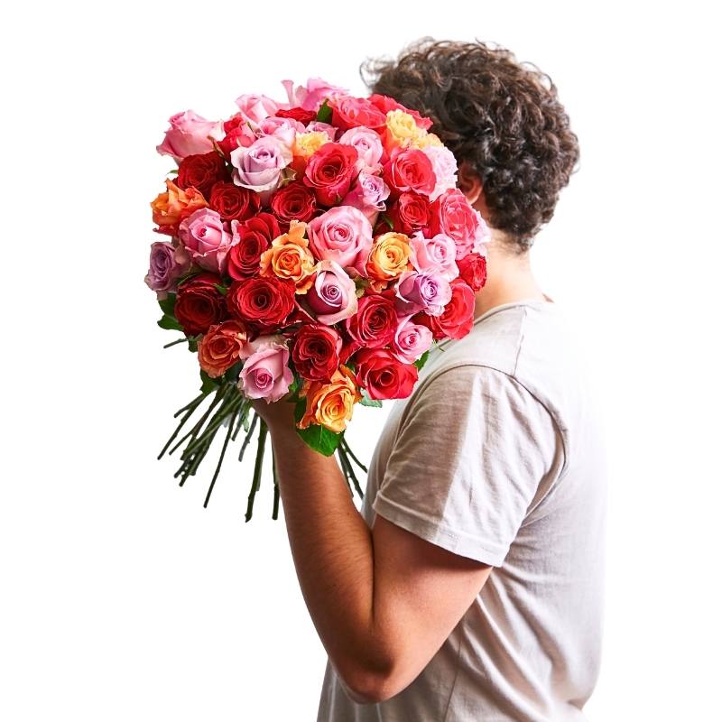 Person holding a large Vibrant Rose Bouquet with multicoloured roses
