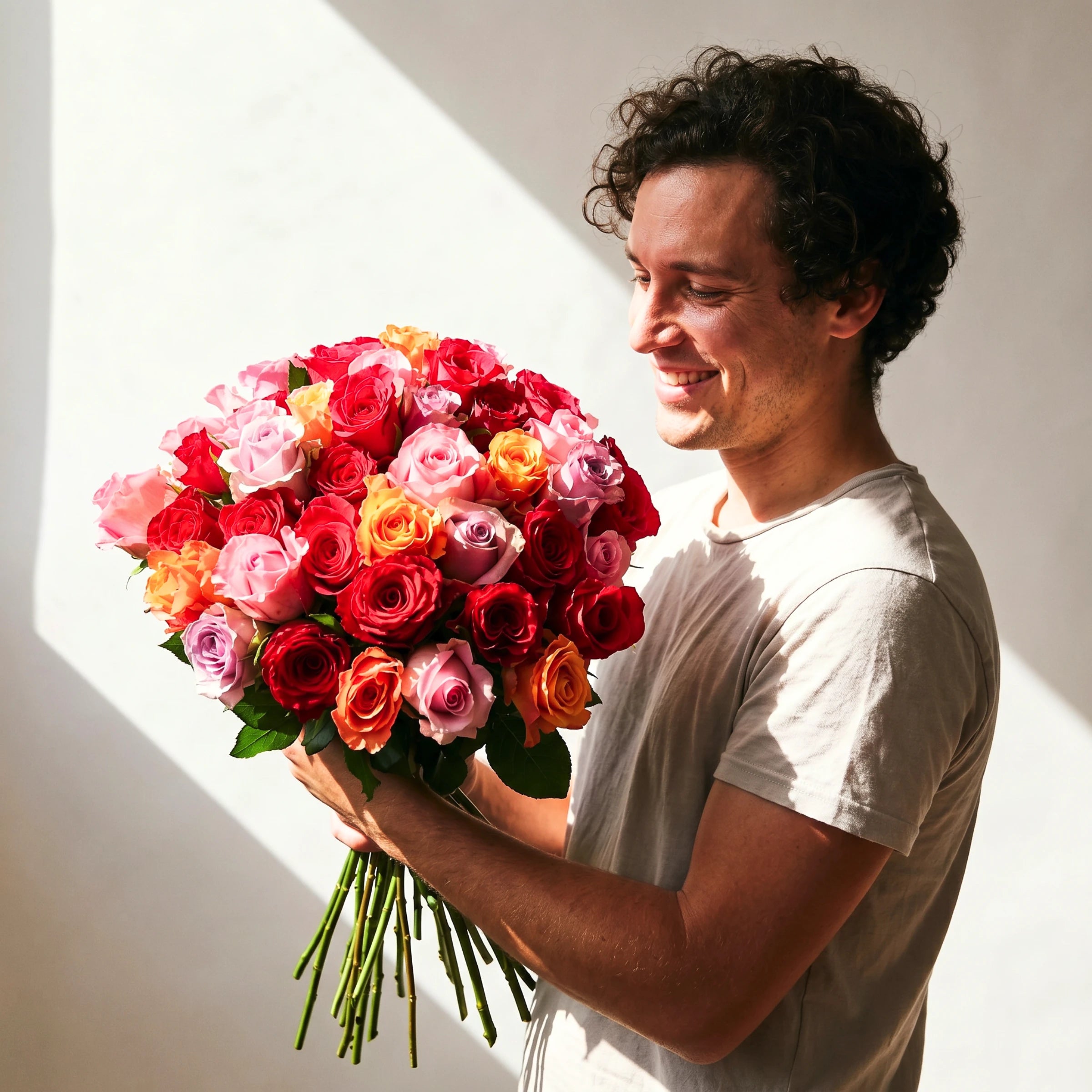 Man holding the Vibrant Rose Bouquet from Fabulous Flowers South Africa, 45 hand-tied red, pink, lilac and orange roses for same-day delivery in Cape Town and Johannesburg