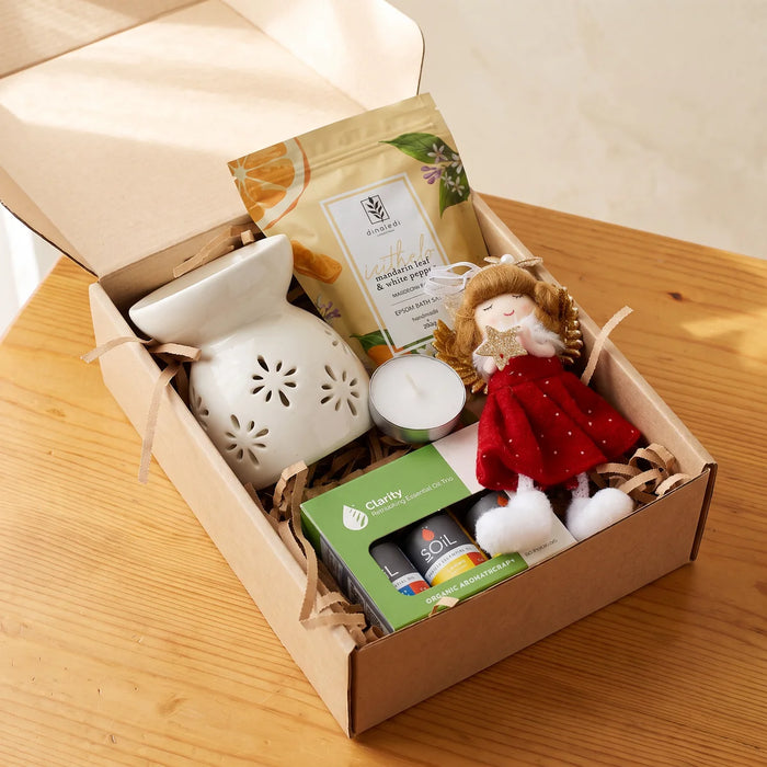 Open kraft gift box with a white ceramic oil burner, bath salts, a tea light, essential oils and a plush angel ornament, Fabulous Flowers South Africa