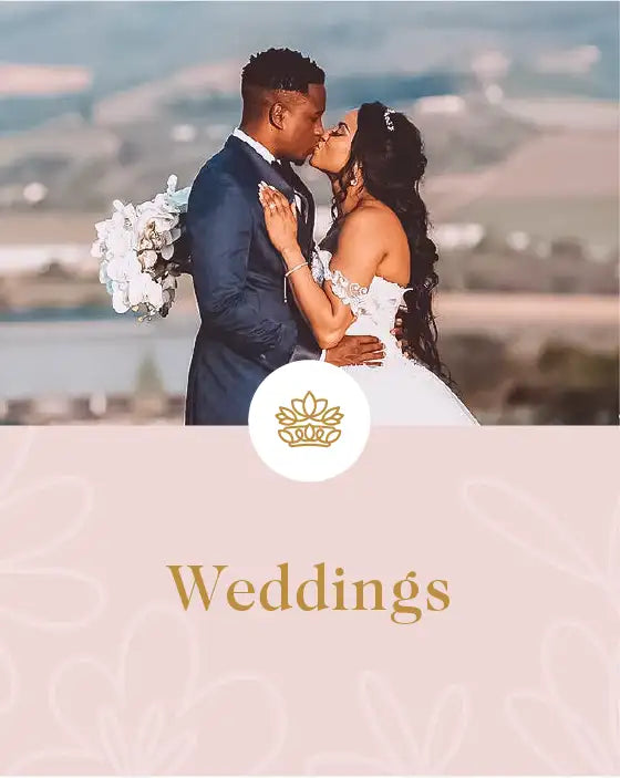 Bride and groom sharing a kiss with a scenic backdrop, bride holding a bouquet. Fabulous Flowers and Gifts. Weddings.
