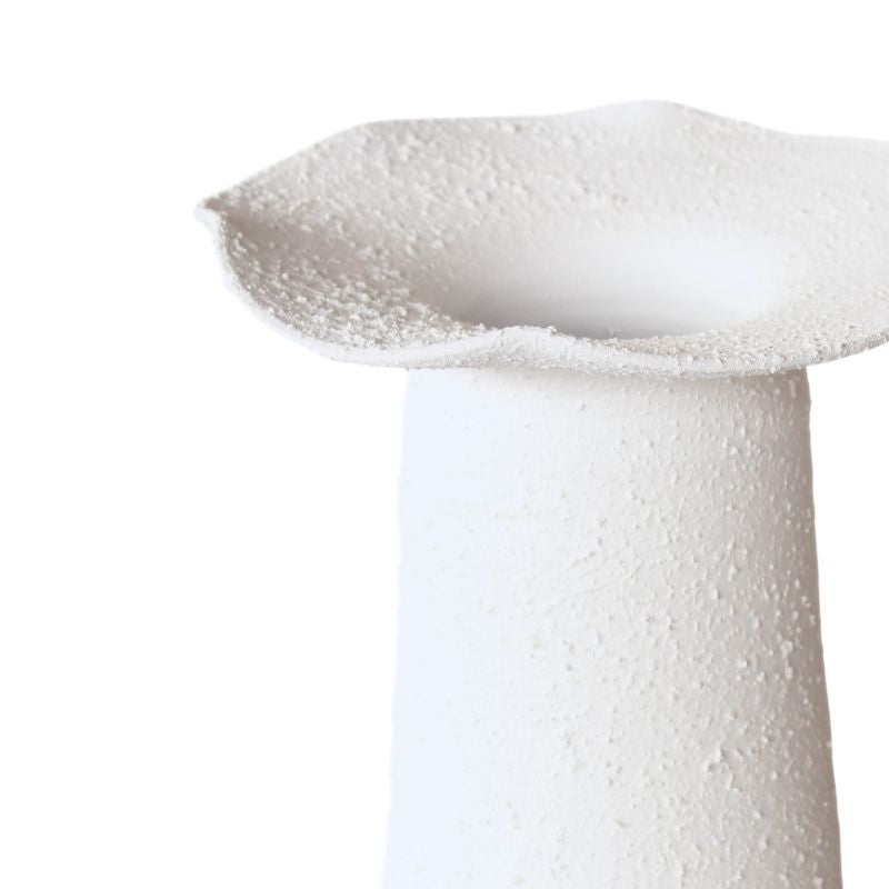 Close-up of a white ceramic vase with textured surface on a white background