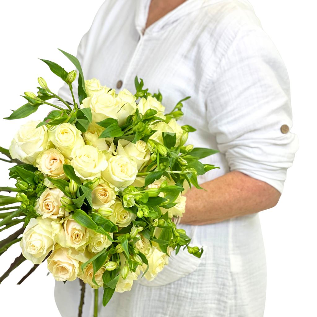 Bouquet of white roses held by a person wearing a white shirt on a white background