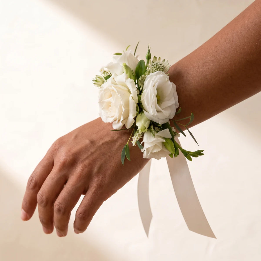 Close-up of ivory roses, white lisianthus and astrantia on a wrist with ivory ribbon, Fabulous Flowers South Africa