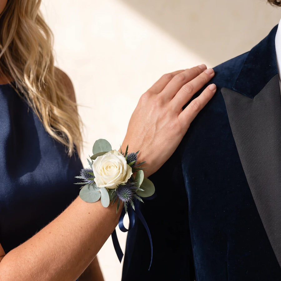 Hand wearing a thistle wrist corsage resting on a velvet jacket shoulder, Fabulous Flowers South Africa
