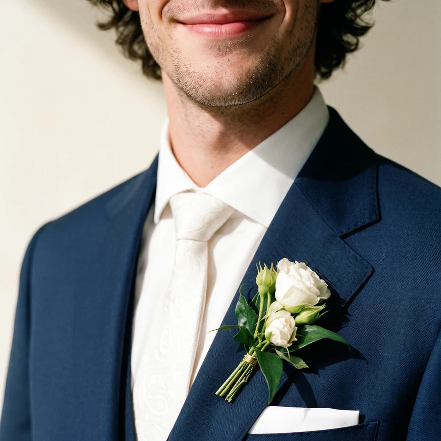 Man in a navy suit and ivory tie wearing a white spray rose boutonniere, Fabulous Flowers South Africa